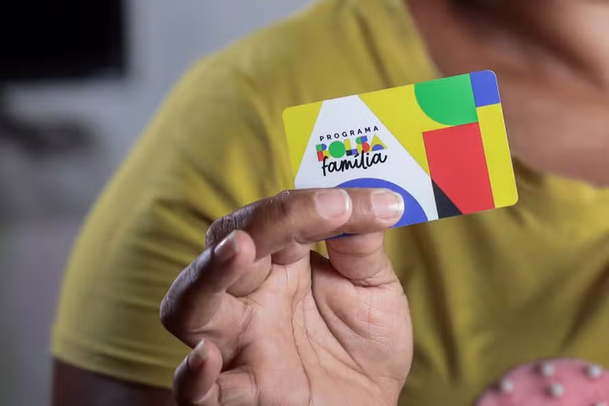 Beneficiária retirando extrato bancário do pagamento do Bolsa Família em agência na Baixada Fluminense.