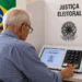 Eleitor idoso votando na urna eletrônica durante o segundo turno para validar a prova de vida do inss.