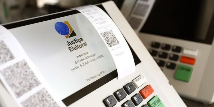 Eleitor depositando voto em urna eletrônica durante o período de votação após as 17h no segundo turno